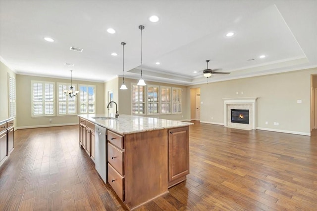 kitchen featuring visible vents, dark wood finished floors, a tray ceiling, a sink, and dishwasher