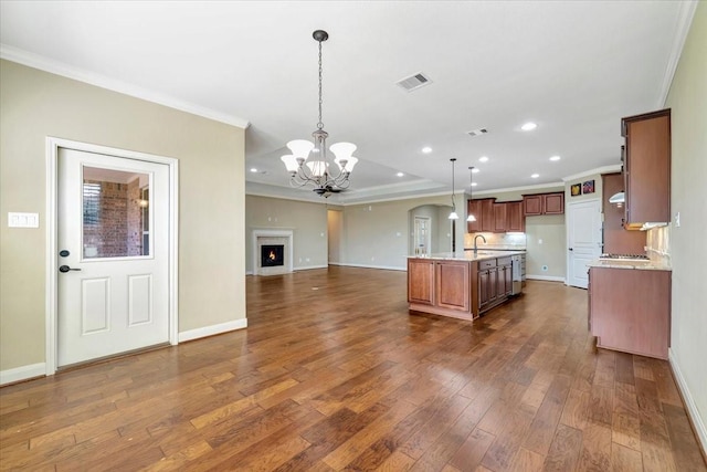 kitchen with visible vents, brown cabinets, ornamental molding, open floor plan, and dark wood-style flooring