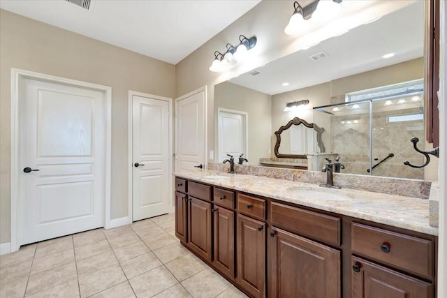 full bath featuring double vanity, visible vents, a stall shower, and a sink