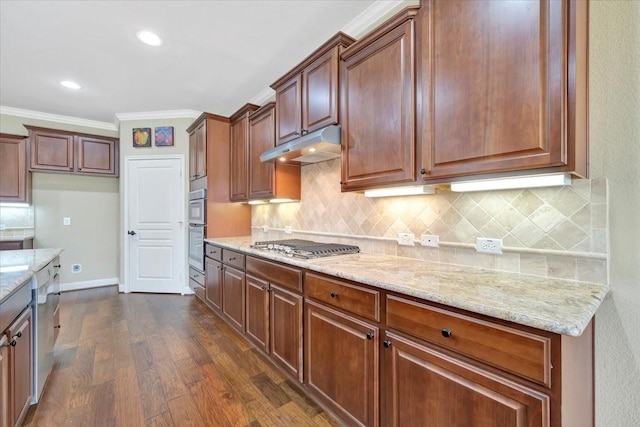 kitchen with light stone counters, dark wood-style floors, under cabinet range hood, and ornamental molding