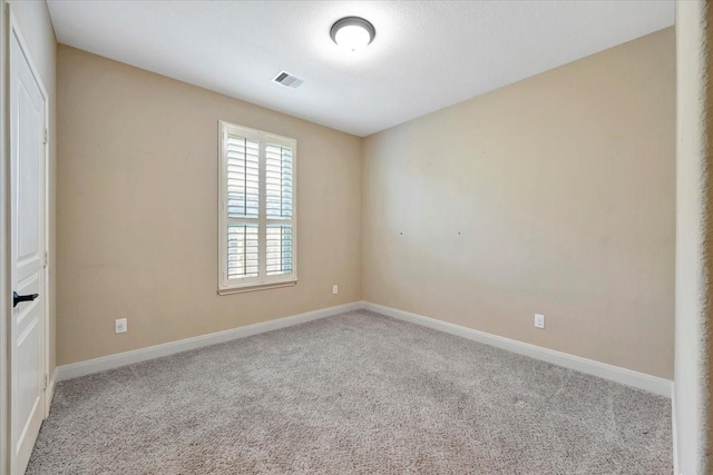 carpeted empty room featuring visible vents and baseboards