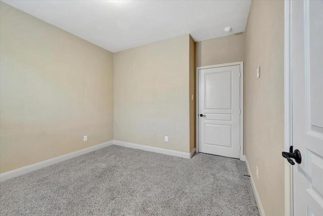 spare room featuring carpet flooring and baseboards