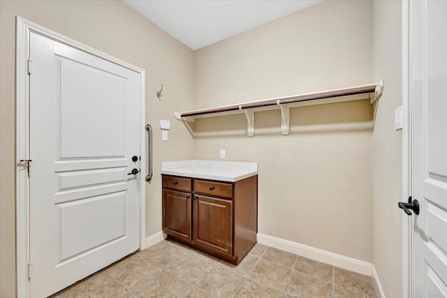 laundry area with baseboards