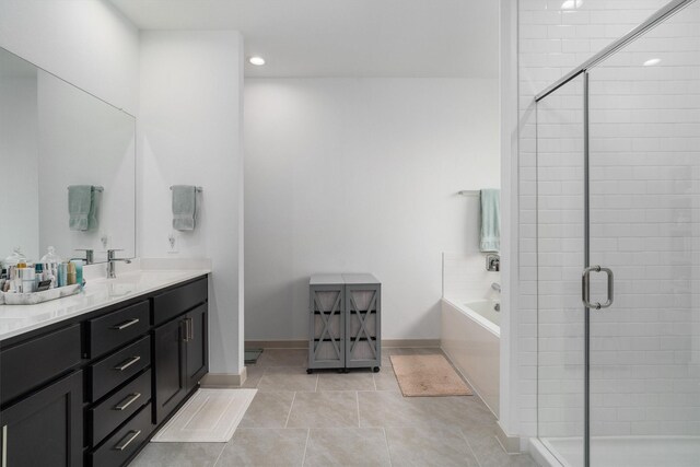 bathroom featuring tile patterned flooring, a shower stall, baseboards, a garden tub, and vanity