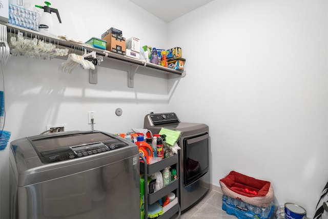 washroom featuring light tile patterned floors, laundry area, and washing machine and clothes dryer