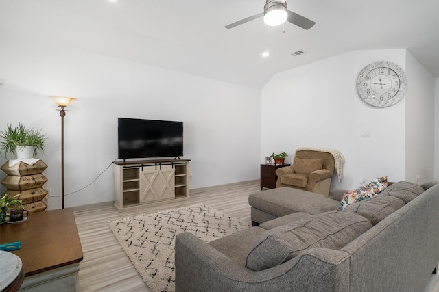 living area with visible vents, lofted ceiling, wood finished floors, and a ceiling fan