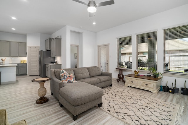 living area with recessed lighting, light wood-type flooring, and a ceiling fan