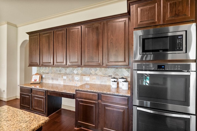 kitchen with light stone counters, ornamental molding, decorative backsplash, dark wood-type flooring, and stainless steel appliances