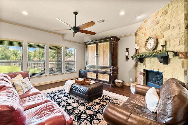 living room featuring visible vents, crown molding, baseboards, wood finished floors, and a ceiling fan