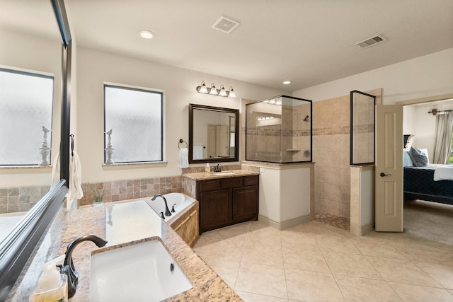 ensuite bathroom with ensuite bath, a garden tub, a walk in shower, and a sink