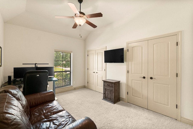 living room featuring ceiling fan, vaulted ceiling, baseboards, and light carpet