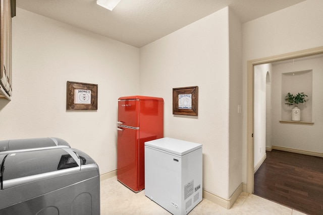 laundry area with cabinet space, independent washer and dryer, and baseboards