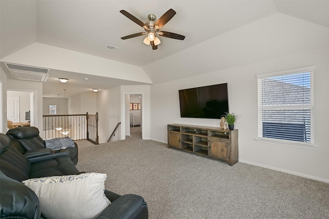 living area with carpet, baseboards, visible vents, attic access, and vaulted ceiling