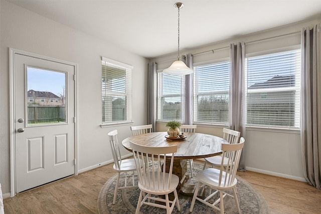 dining area with baseboards and light wood-style floors