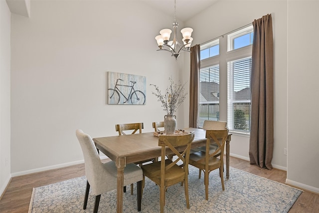 dining room featuring a chandelier, baseboards, and light wood-style flooring