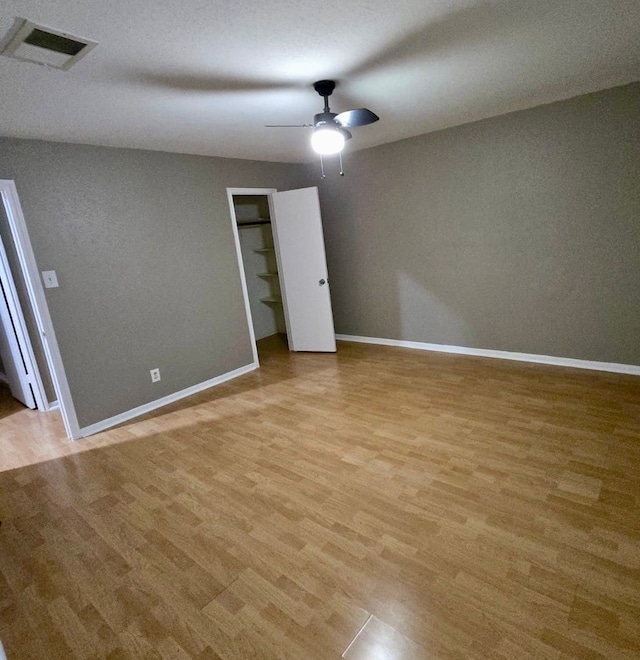 unfurnished bedroom featuring visible vents, ceiling fan, light wood-type flooring, and baseboards