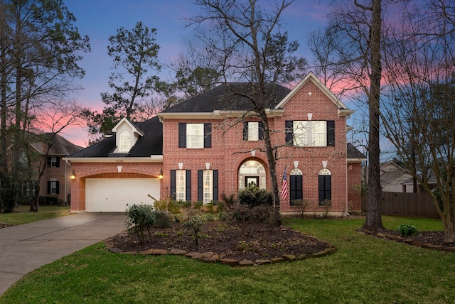 view of front of house featuring a front yard, fence, an attached garage, concrete driveway, and brick siding