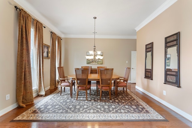 dining space featuring baseboards, wood finished floors, and crown molding