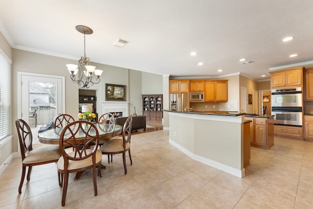 dining area with visible vents, a chandelier, ornamental molding, recessed lighting, and a warm lit fireplace