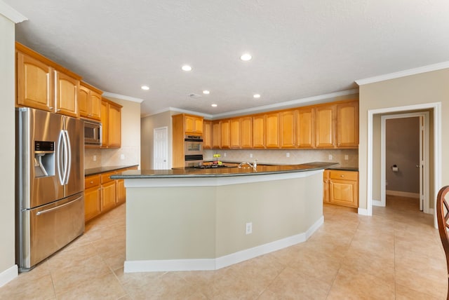 kitchen with dark countertops, stainless steel appliances, tasteful backsplash, and a kitchen island with sink