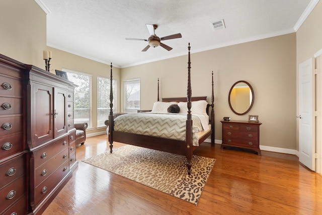 bedroom featuring ornamental molding, visible vents, and light wood-type flooring