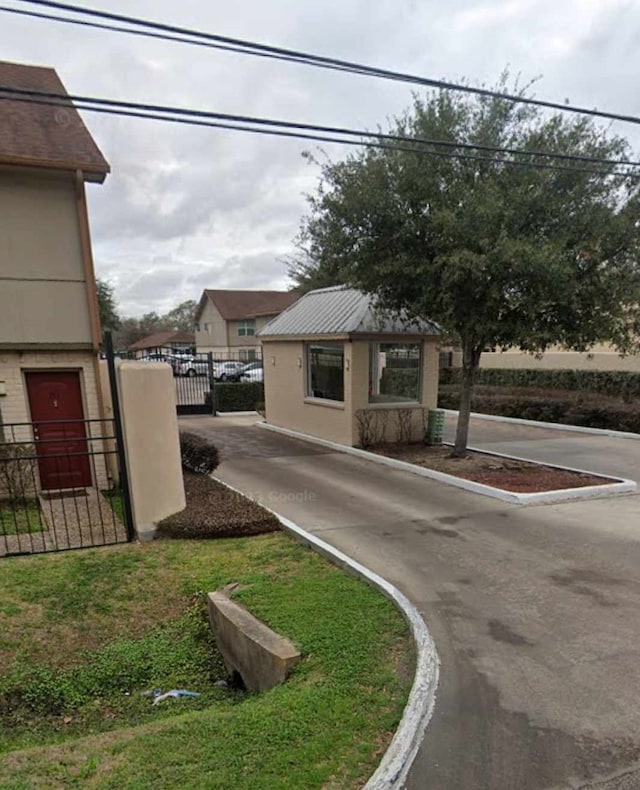 view of street featuring a gate and curbs