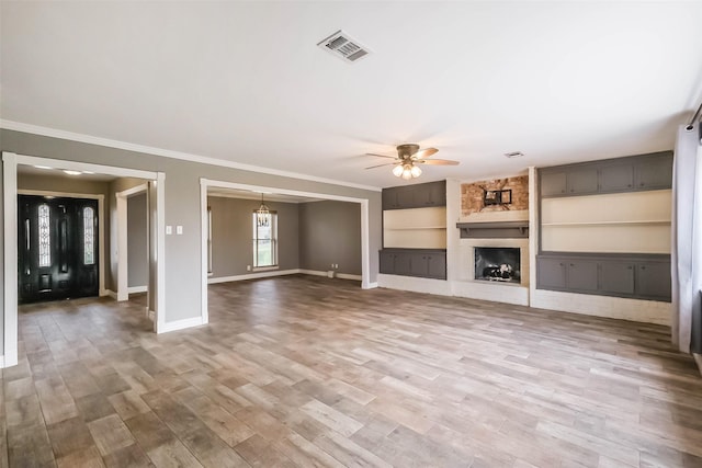 unfurnished living room with visible vents, a ceiling fan, wood finished floors, a large fireplace, and crown molding