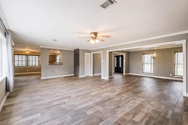 unfurnished living room featuring ceiling fan with notable chandelier, wood finished floors, visible vents, and baseboards