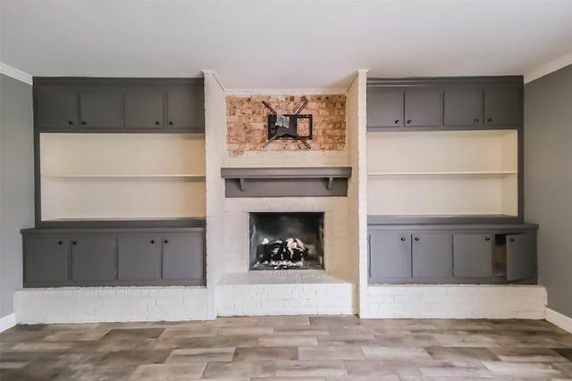 unfurnished living room with wood finished floors, a fireplace, and baseboards