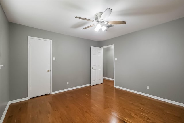 spare room with wood finished floors, baseboards, and ceiling fan