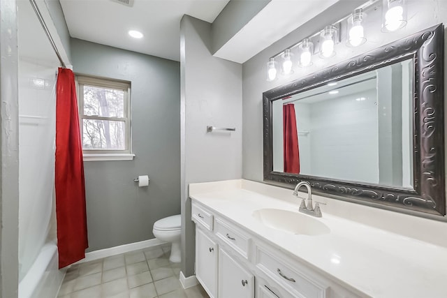 bathroom with baseboards, toilet, vanity, and tile patterned flooring