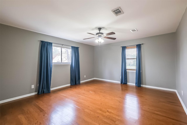 spare room featuring visible vents, light wood-style floors, and a healthy amount of sunlight