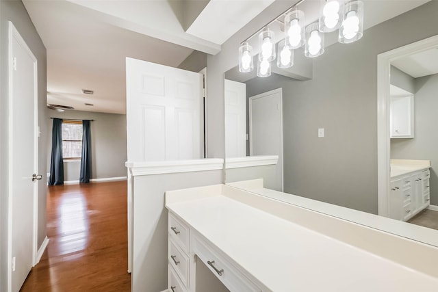 bathroom with vanity, wood finished floors, and baseboards