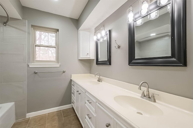 bathroom with tile patterned flooring, double vanity, baseboards, and a sink