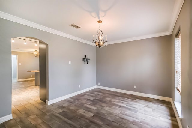 empty room with visible vents, dark wood-type flooring, baseboards, ornamental molding, and arched walkways