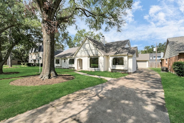 view of front of home with a garage, a front yard, a chimney, and fence