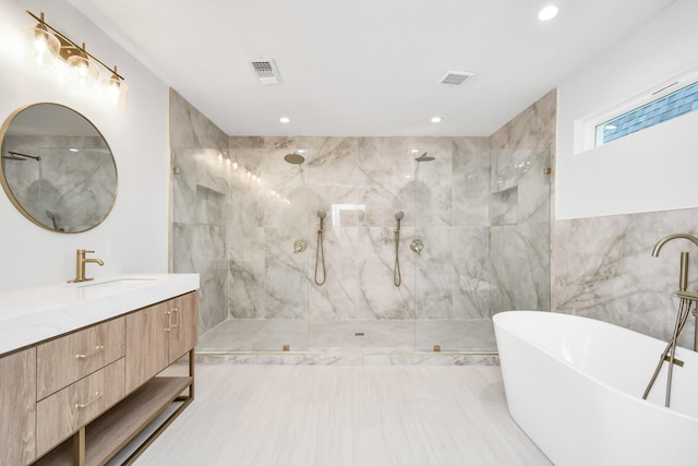 bathroom with a marble finish shower, visible vents, a freestanding bath, and vanity