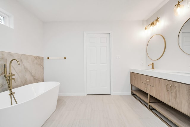 full bathroom with a soaking tub, a sink, baseboards, and double vanity