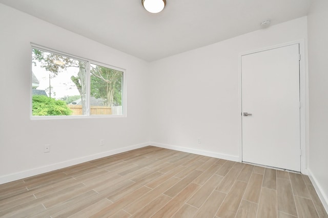 unfurnished room featuring baseboards and wood tiled floor