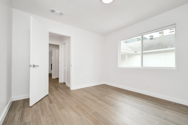 unfurnished room with visible vents, baseboards, and light wood-style floors