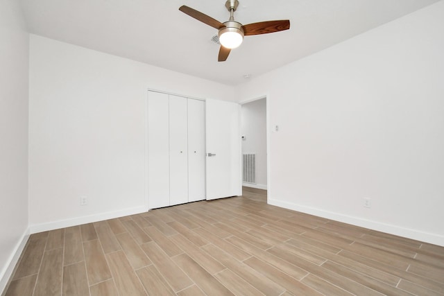 unfurnished bedroom with visible vents, baseboards, ceiling fan, light wood-style flooring, and a closet