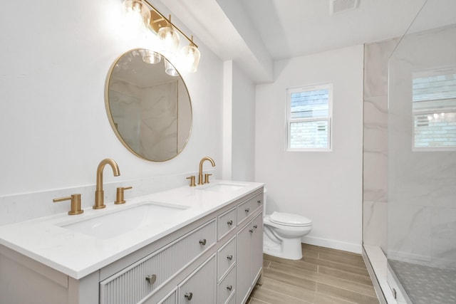 bathroom with a sink, visible vents, toilet, and a walk in shower