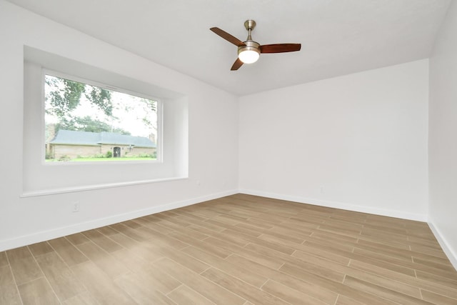 spare room featuring a ceiling fan, baseboards, and wood tiled floor