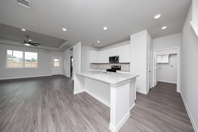 16527 Willow Forest Dr, Conroe, TX 77302 - kitchen with appliances with stainless steel finishes, wood finished floors, white cabinets, baseboards, and recessed lighting
