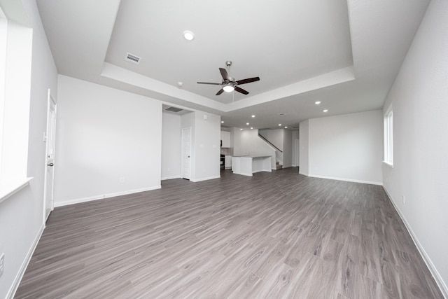 16527 Willow Forest Dr, Conroe, TX 77302 - unfurnished living room with a raised ceiling, a ceiling fan, light wood-style floors, baseboards, and recessed lighting