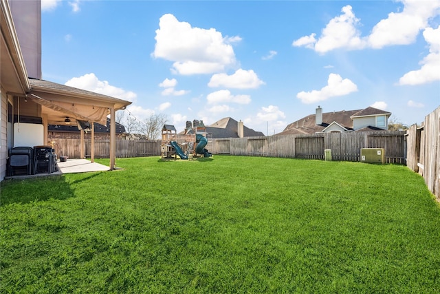 view of yard featuring a patio, a fenced backyard, and a playground