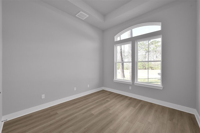 empty room with a wealth of natural light, visible vents, and baseboards