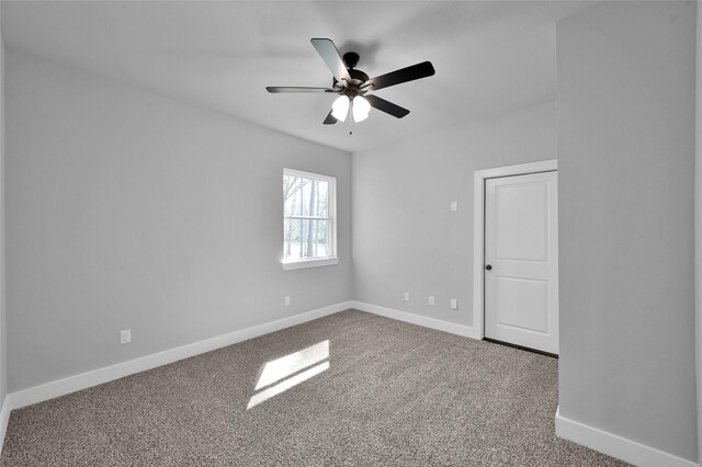 unfurnished room with carpet flooring, ceiling fan, and baseboards