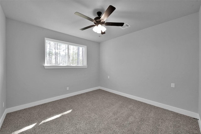 carpeted empty room featuring visible vents, ceiling fan, and baseboards