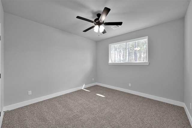 spare room with carpet flooring, ceiling fan, visible vents, and baseboards